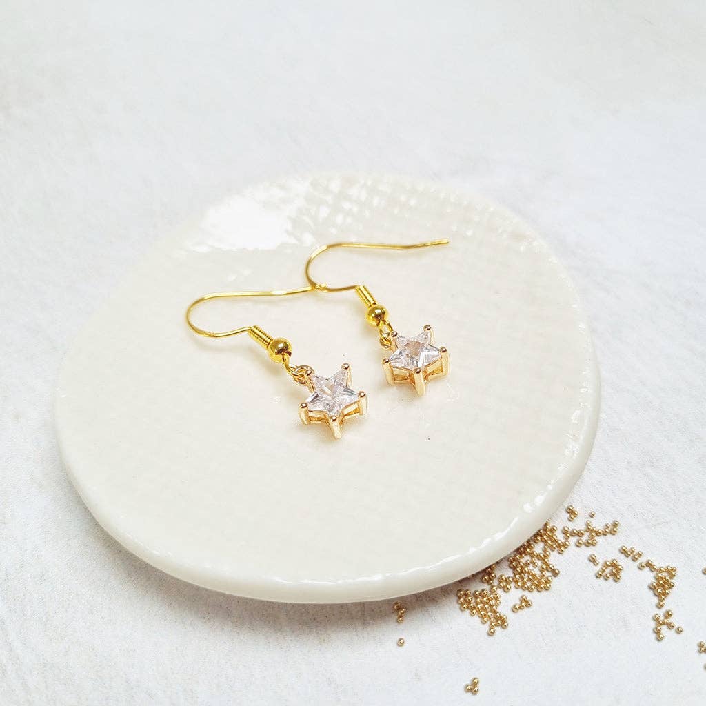 Gold Crystal Star French Hook Earrings in a glass bottle.