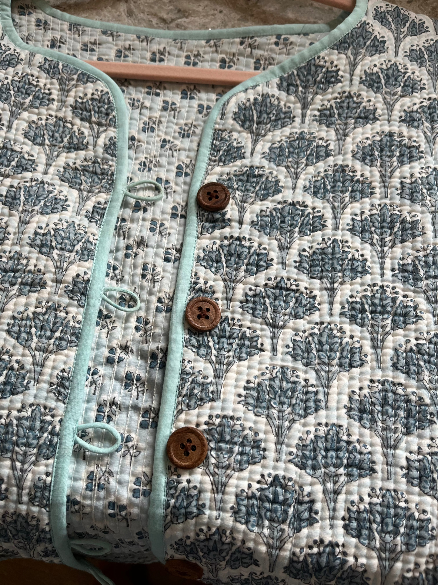 Wood block printed cotton quilted reversible jacket in soft blues.