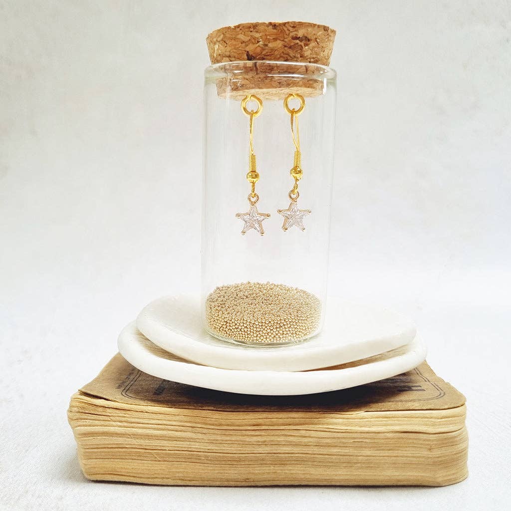 Gold Crystal Star French Hook Earrings in a glass bottle.