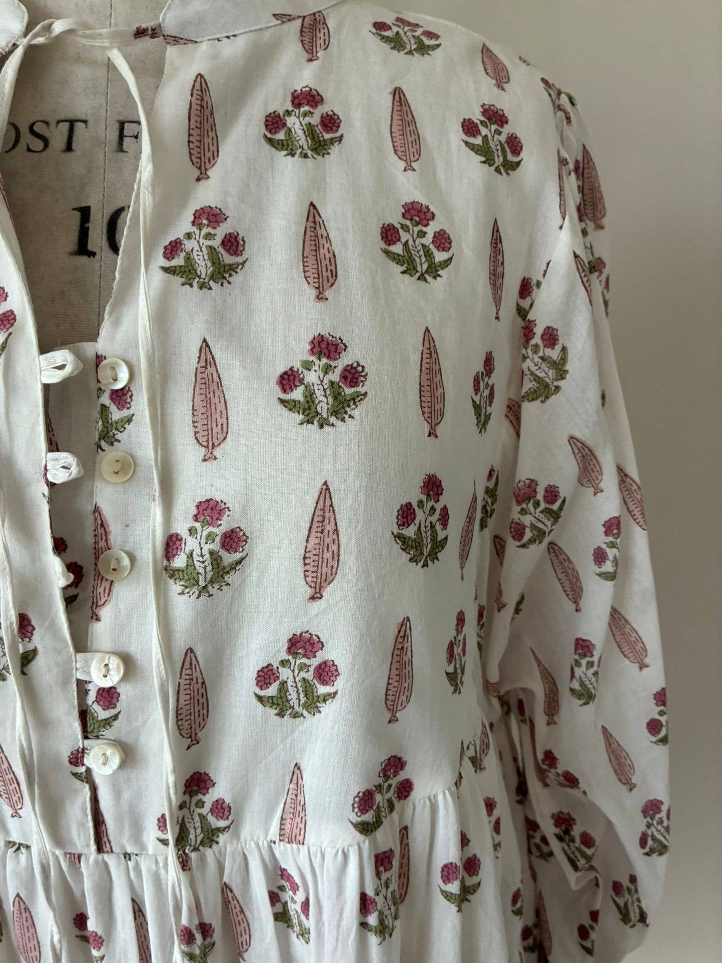 Wood block printed cotton voile dress in soft cream and pink .